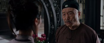 Movie still from “Crouching Tiger, Hidden Dragon” (2000), directed by Ang Lee – An older man talking to a young woman in front of flowers; Close Up shot, Over the shoulder angle