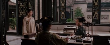 Movie still from “Crouching Tiger, Hidden Dragon” (2000), directed by Ang Lee – A group of people sitting around a table; Wide shot, Over the shoulder angle