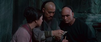 Movie still from “Crouching Tiger, Hidden Dragon” (2000), directed by Ang Lee – A group of people standing around looking at a piece of paper; Medium shot, High angle