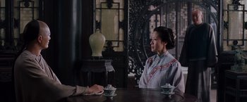 Movie still from “Crouching Tiger, Hidden Dragon” (2000), directed by Ang Lee – A woman sitting at a table with a cup of tea; Medium shot, Over the shoulder angle