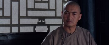 Movie still from “Crouching Tiger, Hidden Dragon” (2000), directed by Ang Lee – A man with a shaved head is standing in front of a wall; Close Up shot, Low angle
