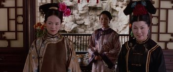 Movie still from “Crouching Tiger, Hidden Dragon” (2000), directed by Ang Lee – Two women in traditional chinese clothing standing next to each other in front of a stone wall; Medium shot, Over the shoulder angle
