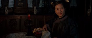 Movie still from “Crouching Tiger, Hidden Dragon” (2000), directed by Ang Lee – A woman sitting at a table with a bowl of food; Medium shot, Over the shoulder angle