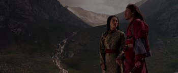 Movie still from “Crouching Tiger, Hidden Dragon” (2000), directed by Ang Lee – Two people standing in front of a mountain range; Medium shot, Low angle