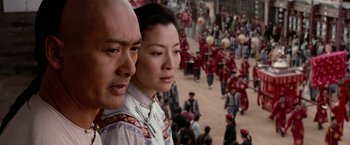 Movie still from “Crouching Tiger, Hidden Dragon” (2000), directed by Ang Lee – A man and a woman standing next to each other in front of a crowd of people; Close Up shot, Over the shoulder angle