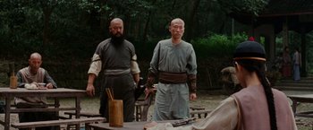 Movie still from “Crouching Tiger, Hidden Dragon” (2000), directed by Ang Lee – Two men standing next to each other near a table; Medium shot, Over the shoulder angle