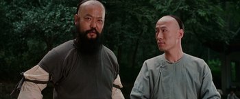 Movie still from “Crouching Tiger, Hidden Dragon” (2000), directed by Ang Lee – Two men standing next to each other near a forest; Close Up shot, Low angle