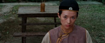 Movie still from “Crouching Tiger, Hidden Dragon” (2000), directed by Ang Lee – A young woman wearing a black hat and a pink shirt; Close Up shot, Over the shoulder angle