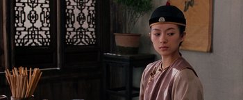 Movie still from “Crouching Tiger, Hidden Dragon” (2000), directed by Ang Lee – A young man wearing a black hat in a living room; Close Up shot, Over the shoulder angle