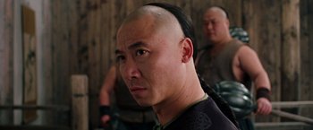 Movie still from “Crouching Tiger, Hidden Dragon” (2000), directed by Ang Lee – A man with a shaved head is looking at the camera; Close Up shot, Over the shoulder angle