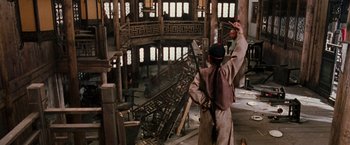 Movie still from “Crouching Tiger, Hidden Dragon” (2000), directed by Ang Lee – A man holding a sword in an abandoned building; Wide shot, High angle
