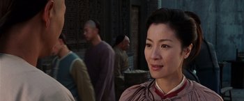 Movie still from “Crouching Tiger, Hidden Dragon” (2000), directed by Ang Lee – A woman standing in front of a group of people; Close Up shot, Over the shoulder angle