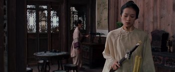 Movie still from “Crouching Tiger, Hidden Dragon” (2000), directed by Ang Lee – A woman holding a gun while standing next to another woman; Medium shot, Over the shoulder angle