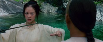 Movie still from “Crouching Tiger, Hidden Dragon” (2000), directed by Ang Lee – A woman pointing at a man with a sword in front of a body of water; Medium shot, Over the shoulder angle