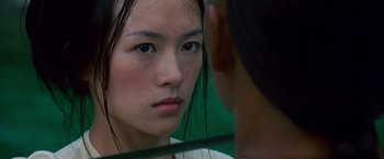Movie still from “Crouching Tiger, Hidden Dragon” (2000), directed by Ang Lee – A woman looking into a mirror while standing up; Close Up shot, Over the shoulder angle