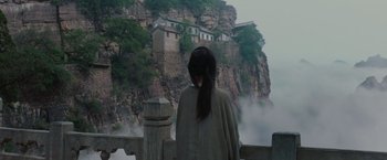 Movie still from “Crouching Tiger, Hidden Dragon” (2000), directed by Ang Lee – A woman standing on a bridge looking out at a cliff; Extreme Wide shot, Over the shoulder angle