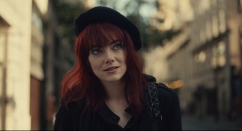 Movie still from “Cruella” (2021), directed by Craig Gillespie – A person with red hair wearing a hat; Close Up shot, Over the shoulder angle
