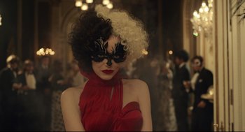 Movie still from “Cruella” (2021), directed by Craig Gillespie – A woman in a black and red dress with a black mask on her face; Close Up shot, Over the shoulder angle