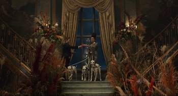 Movie still from “Cruella” (2021), directed by Craig Gillespie – Two people and two dogs on a staircase; Wide shot, Low angle