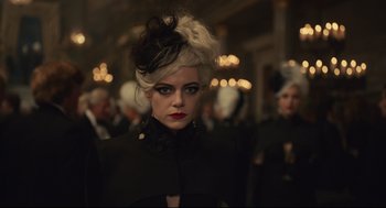 Movie still from “Cruella” (2021), directed by Craig Gillespie – A woman in a black outfit with white hair; Close Up shot, Over the shoulder angle