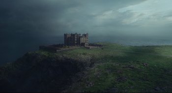Movie still from “Cruella” (2021), directed by Craig Gillespie – A castle on top of a green hill; Extreme Wide shot, High angle