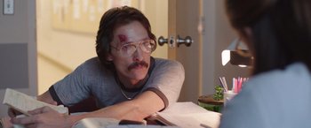 Movie still from “Dallas Buyers Club” (2013), directed by Jean-Marc Vallée – A man sitting at a table with a book in front of him; Medium shot, Over the shoulder angle