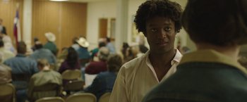 Movie still from “Dallas Buyers Club” (2013), directed by Jean-Marc Vallée – A man in a crowd of people sitting in a room; Close Up shot, Over the shoulder angle
