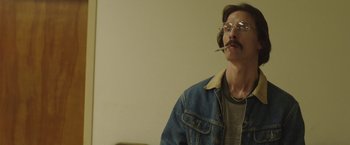 Movie still from “Dallas Buyers Club” (2013), directed by Jean-Marc Vallée – A man smoking a cigarette while wearing a jean jacket; Medium shot, Low angle
