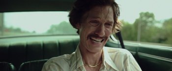 Movie still from “Dallas Buyers Club” (2013), directed by Jean-Marc Vallée – A person in a car smiling; Close Up shot, Low angle