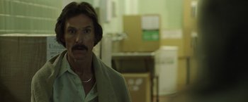 Movie still from “Dallas Buyers Club” (2013), directed by Jean-Marc Vallée – A man with a mustache standing next to boxes; Close Up shot, Over the shoulder angle
