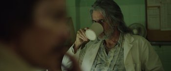 Movie still from “Dallas Buyers Club” (2013), directed by Jean-Marc Vallée – A man with long grey hair is drinking from a cup; Close Up shot, Over the shoulder angle