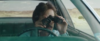 Movie still from “Dallas Buyers Club” (2013), directed by Jean-Marc Vallée – A man looking through binoculars while sitting in a car; Close Up shot, Over the shoulder angle