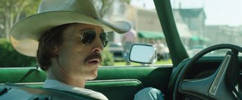 Movie still from “Dallas Buyers Club” (2013), directed by Jean-Marc Vallée – A man in a cowboy hat driving in a car; Close Up shot, Over the shoulder angle