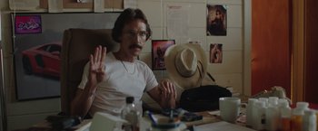 Movie still from “Dallas Buyers Club” (2013), directed by Jean-Marc Vallée – A man sitting at a table with a hat on; Medium shot, High angle