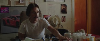 Movie still from “Dallas Buyers Club” (2013), directed by Jean-Marc Vallée – A man sitting at a table in front of a laptop computer; Medium shot, Over the shoulder angle