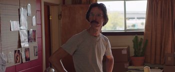 Movie still from “Dallas Buyers Club” (2013), directed by Jean-Marc Vallée – A man with a mustache wearing glasses and a t - shirt; Medium shot, Low angle