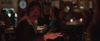 Movie still from “Dallas Buyers Club” (2013), directed by Jean-Marc Vallée – A man with a mustache and a beard is holding his hand out to a woman; Medium shot, Over the shoulder angle