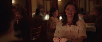 Movie still from “Dallas Buyers Club” (2013), directed by Jean-Marc Vallée – A woman sitting at a table in front of other people; Medium shot, Over the shoulder angle