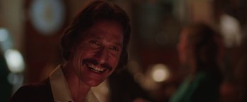 Movie still from “Dallas Buyers Club” (2013), directed by Jean-Marc Vallée – A person with a mustache smiling; Close Up shot, Over the shoulder angle