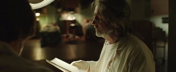 Movie still from “Dallas Buyers Club” (2013), directed by Jean-Marc Vallée – An older man with long white hair and glasses is reading a book; Close Up shot, Low angle