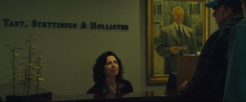 Movie still from “Dark Waters” (2019), directed by Todd Haynes – A woman sitting at a piano in front of a painting; Medium shot, Low angle