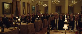 Movie still from “Dark Waters” (2019), directed by Todd Haynes – A group of people sitting at tables with wine glasses; Wide shot, High angle