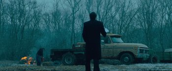 Movie still from “Dark Waters” (2019), directed by Todd Haynes – A man standing in front of an old pick - up truck; Wide shot, Low angle