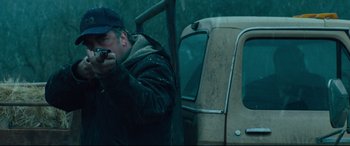 Movie still from “Dark Waters” (2019), directed by Todd Haynes – A man standing next to an old truck in the rain; Medium shot, Low angle