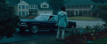 Movie still from “Dark Waters” (2019), directed by Todd Haynes – A woman standing in front of a car on a rainy day; Wide shot, Over the shoulder angle