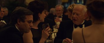 Movie still from “Dark Waters” (2019), directed by Todd Haynes – A group of people sitting at a table with wine glasses; Close Up shot, Over the shoulder angle