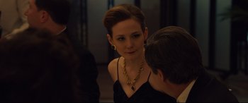 Movie still from “Dark Waters” (2019), directed by Todd Haynes – A woman wearing a black dress and a gold necklace; Close Up shot, Over the shoulder angle