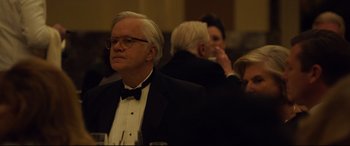 Movie still from “Dark Waters” (2019), directed by Todd Haynes – An older man in a tuxedo is sitting at a table; Close Up shot, Over the shoulder angle
