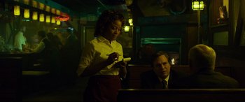 Movie still from “Dark Waters” (2019), directed by Todd Haynes – A woman standing next to a man in a restaurant; Medium shot, Over the shoulder angle