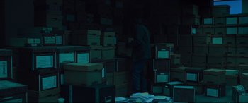 Movie still from “Dark Waters” (2019), directed by Todd Haynes – A man standing in front of stacks of boxes; Wide shot, High angle